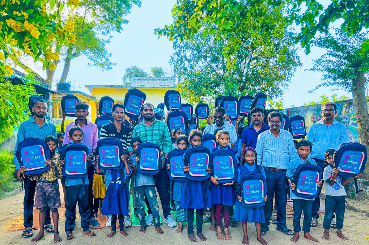 Village children joyfully holding up newly distributed school bags