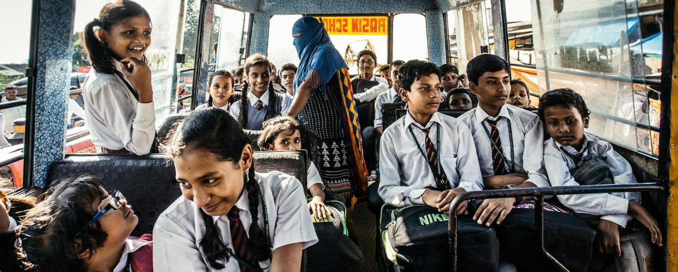 Group of school children in uniforms on a bus in Wadgaon, India.