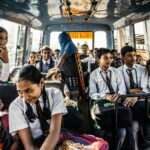 Group of school children in uniforms on a bus in Wadgaon, India.