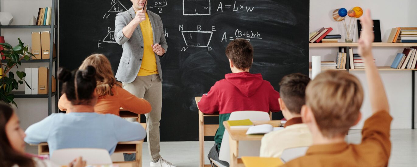 Teacher explaining geometry as students engage in a modern classroom setting.